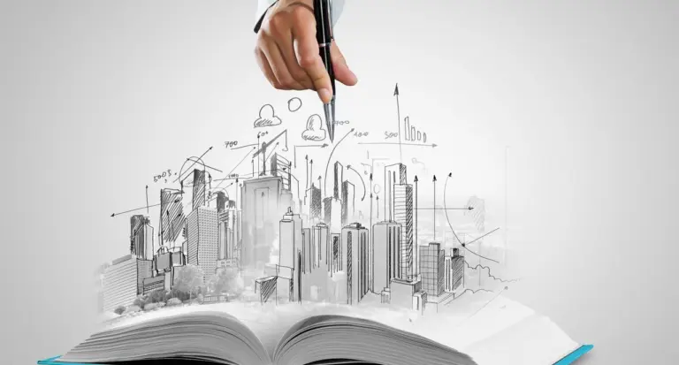 A hand with a pen sketching a city skyline that rises out of an open book